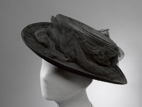 Zwarte hoed van stroband met een draperie van zwarte voile, met strik linksvoor