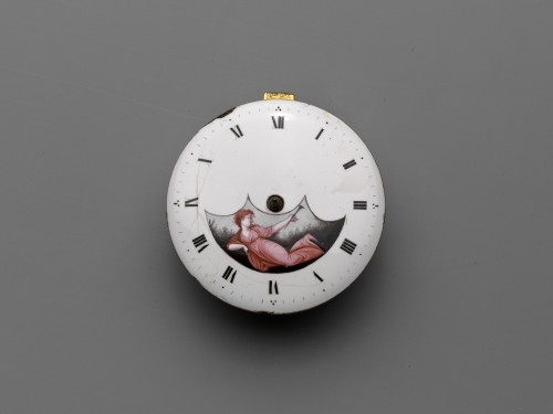 Horloge met witgeëmailleerde wijzerplaat, waarin een liggende vrouw met een bazuin.