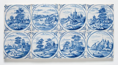 Tegelveld met een blauwwit decor van landschappen in omlijstingen