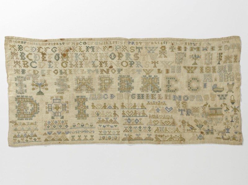 Lettermerklap met alfabet, deels rijk gewerkte letters, deels opengewerkt, rechts onder motiefjes, jaartal 1711