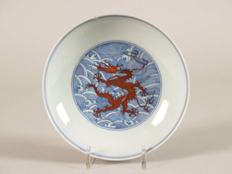 Schaal met decor van draak op ondergrond van golven