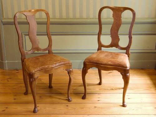 Twee achttiende-eeuwse stoelen van hout en een leren zitting