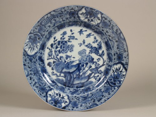 Schotel met decor van rotspartij met pioenrozen, prunus en cartouches